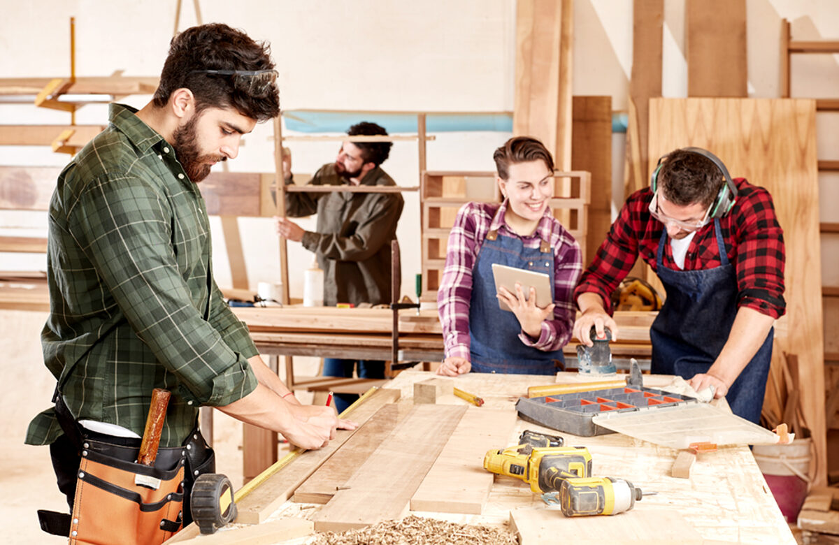 Joiner apprentices in training at the workbench in the carpentry workshop Schlagwort(e): carpenter, joiner, apprenticeship, apprentice, wood processing, team, carpentry, wood, woodworker, cooperation, workbench, measure, accuracy, care, tape measure, trade, learn, craftsman, artisan, laptop, computer, workshop, operation, trainee, tool, working, man, work, profession, company, construction, worker, blue collar worker, male, people